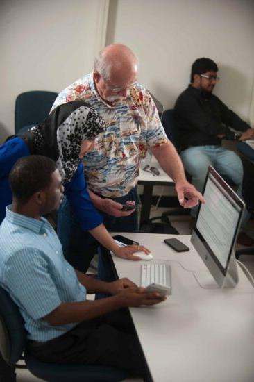 A professor showing a student an assignment on the computer.